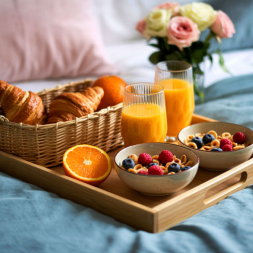 A relaxing breakfast in bed tray with croissants, fruit, and orange juice at the Elements of the Soul Retreat by Eclectic Lyfe LLC